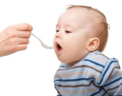 Baby being fed infant cereal from a spoon