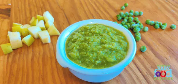 A bowl of pea and apple puree, with chopped apple and frozen peas