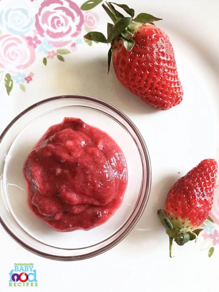 Fresh strawberries beside a bowl of  strawberry, banana, and beet mash
